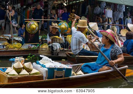 RATCHABURI, THAILAND - MARCH 24: Local peoples sell fruits, food and souvenirs at famous tourist attraction Damnoen Saduak floating market on March 24, 2014 in Ratchaburi, Thailand.