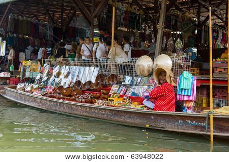 RATCHABURI, THAILAND - MARCH 24: Local peoples sell fruits, food and souvenirs at famous tourist attraction Damnoen Saduak floating market on March 24, 2014 in Ratchaburi, Thailand.