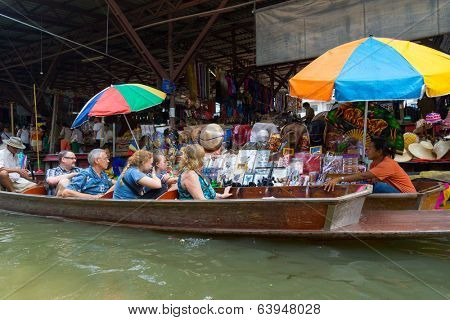 RATCHABURI, THAILAND - MARCH 24: Local peoples sell fruits, food and souvenirs at famous tourist attraction Damnoen Saduak floating market on March 24, 2014 in Ratchaburi, Thailand.