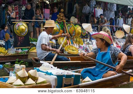 RATCHABURI, THAILAND - MARCH 24: Local peoples sell fruits, food and souvenirs at famous tourist attraction Damnoen Saduak floating market on March 24, 2014 in Ratchaburi, Thailand.