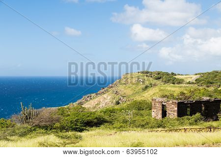 Old Building On Green Hill Over Blue Sea