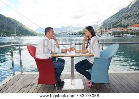 happy young couple having lanch at beautiful restaurant on by the sea on  beach