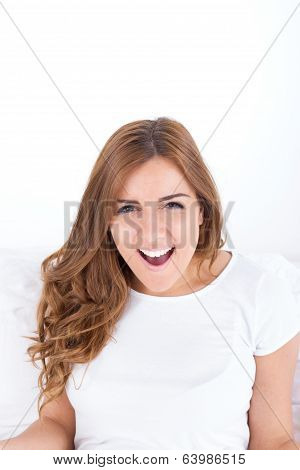 Happy Sensual Young Woman Sittng In Bed And Smiling To Camera