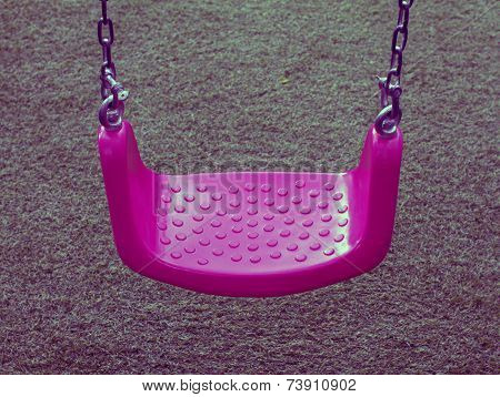 Pink swing on green grasses