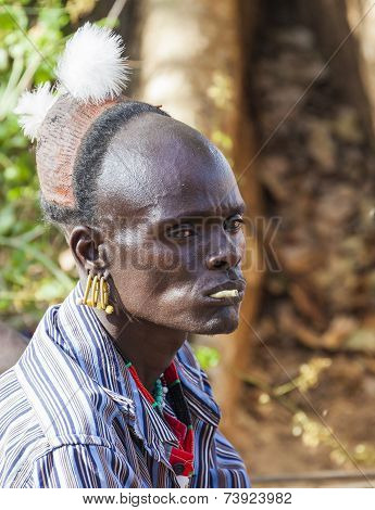 Traditionally Dressed Hamar Man With Chewing Stick In His Mouth At A Bull Jumping Ceremony.