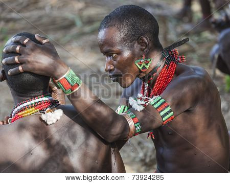 Hamar Men Paint Each Other's Face In A Preparation To A Bull Jumping Ceremony.