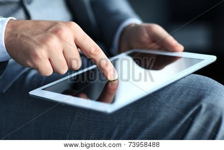Young adult working on a digital tablet. Businessman holding digital tablet