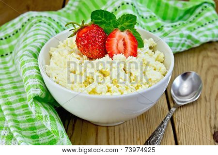 Curd with strawberries in bowl on board