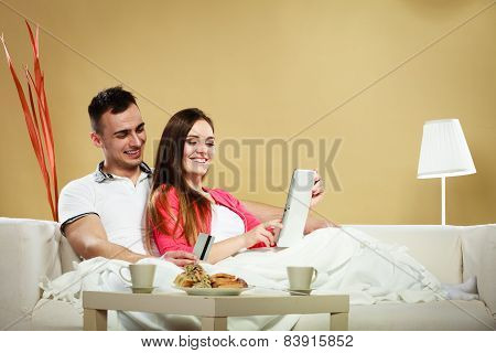 Young Couple With Tablet And Credit Card At Home