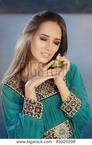 Young Woman Holding Perfume Bottle in Seaside Landscape