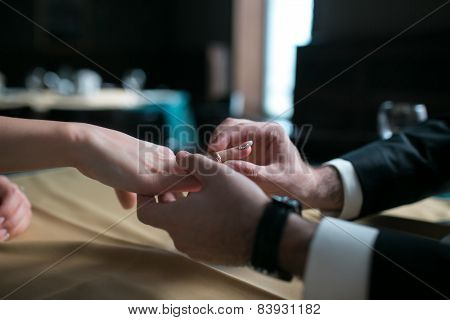 Groom Wears The Ring Bride