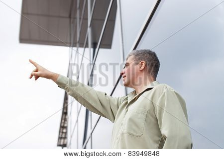 Young Businessman Showing Away At Commercial Building