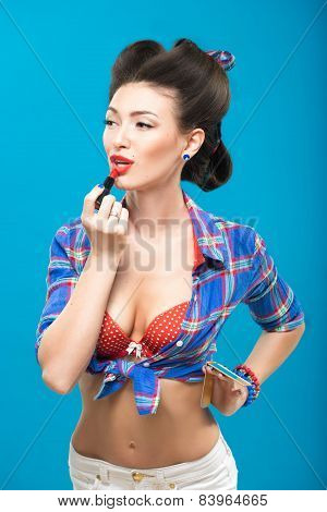 Sexy young pin-up girl doing make-up
