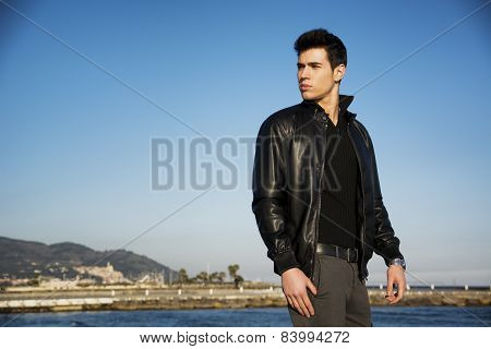 Handsome young man at the seaside overlooking the ocean or sea