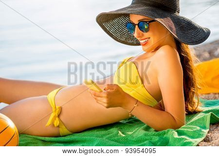 Woman using mobile phone on the beach