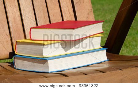Red, yellow and blue books on a wooden chair