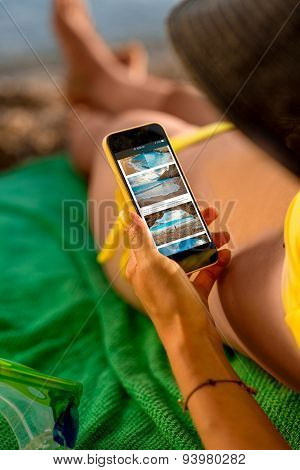 Woman using mobile phone on the beach