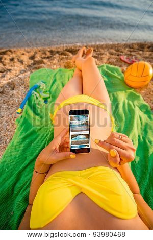 Woman using mobile phone on the beach