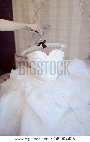 Beautiful white wedding dress for bride indoors. Beauty of bridal gown for marriage. Female lace clothes for celebration