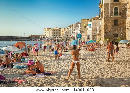CEFALU,SICILY - JULY. 27. 2016: Unidentified people on sandy beach in Cefalu, Sicily, Italy at Sep 16, 2014. Cefalu is an attractive historic town and seaside resort.