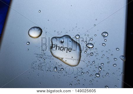 PARIS FRANCE - SEP 26 2016: New Apple iPhone 7 Plus unboxing and testing - iPhone engraved logo covered with rain drops. New iPhone7 is one of the best waterproof smart phone in the world