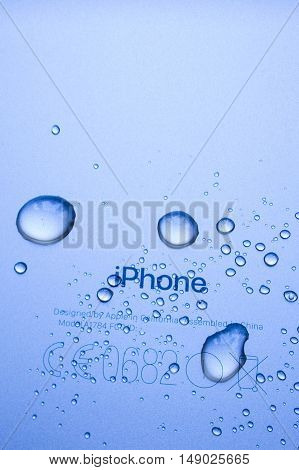 PARIS FRANCE - SEP 26 2016: New Apple iPhone 7 Plus unboxing and testing - iPhone engraved logo covered with rain drops. New iPhone7 is one of the best waterproof smart phone in the world