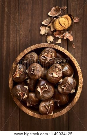 Freshly roasted or baked chestnuts in wooden bowl photographed overhead with natural light (Selective Focus Focus on the chestnuts on the top)