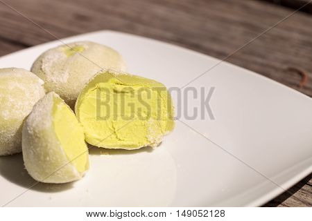 Green tea mochi ice cream bonbon desert on a white plate