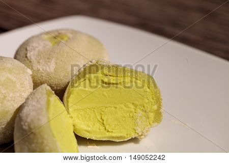 Green tea mochi ice cream bonbon desert on a white plate