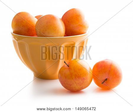 Ripe yellow plums in bowl isolated on white background.