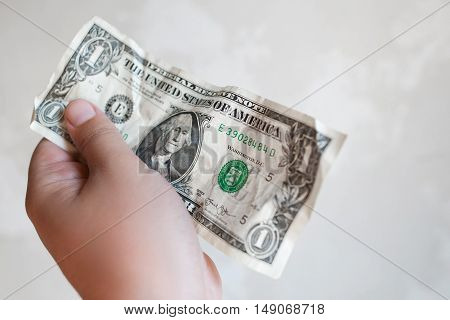 UKRAINE, KHARKIV- SEPTEMBER 4 , 2016. Male hand holding one dollar bill in giving gesture. Rumbled american money, white background. Buying, paying, shopping, finance concept