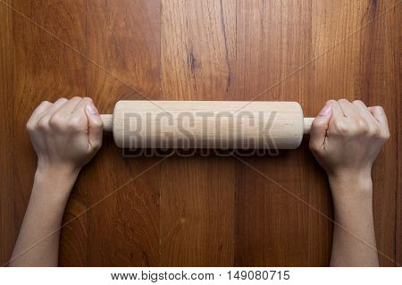 wooden rollerfemale cook rolling dough with rolling-pin. Closeup view