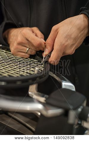Tennis Stringer Tying Knots And Cutting String With Pliers