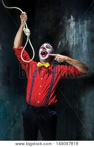 The scary clown and rope for hanging on dack. Halloween concept of horror and murderer