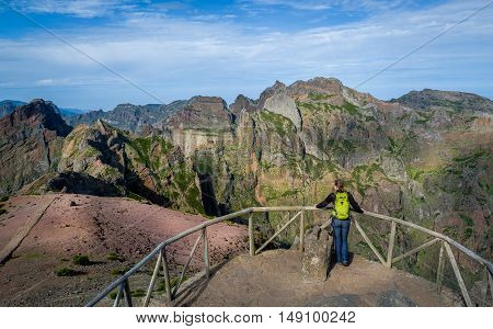 Woman hiker is looking at the long way from Pico Arieiro to Pico Ruivo. Madeira island, Portugal.