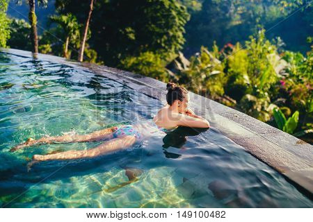 Young Beautiful Woman In Outdoors Swimming Pool. Holiday Concept With Woman Sunbathing In Infinity S