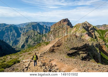 Tourist woman walking on the mountains of Madeira island. Pico Arieiro to Pico Ruivo hiking path, Madeira island, Portugal.