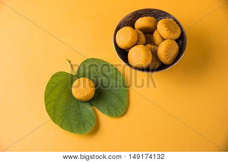 indian festival dussehra or vijayadashmi or ayudh puja, showing apta leaf or Bauhinia racemosa with traditional indian sweets pedha in silver bowl