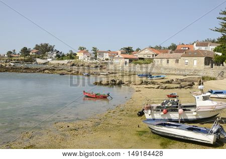ISLAND OF AROUSA, SPAIN - AUGUST 8, 2016: Fishing boats at the shore of a beach in Island of Arousa in the province of Pontevedra Galicia Spain.