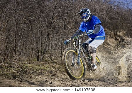 Extreme mountainbiker rides on path in mud
