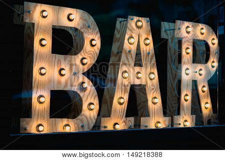 Vintage bar sign illuminated against a dark background
