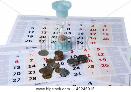 Hourglass standing on calendar leaves and some small coins
