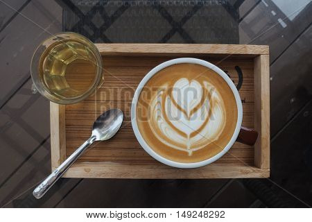hot milk art coffee on wooden plate