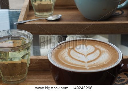 hot milk art coffee on wooden plate