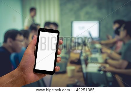 Hand holding smart phone bank screen for textture. blur background meeting room with vintage effect.