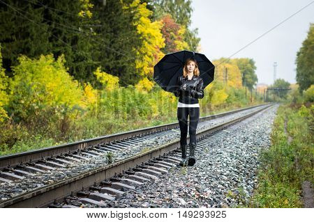 Girl, Umbrella And Rails In Autumn Day
