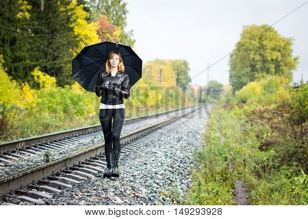 Girl, Umbrella And Rails In Autumn Day