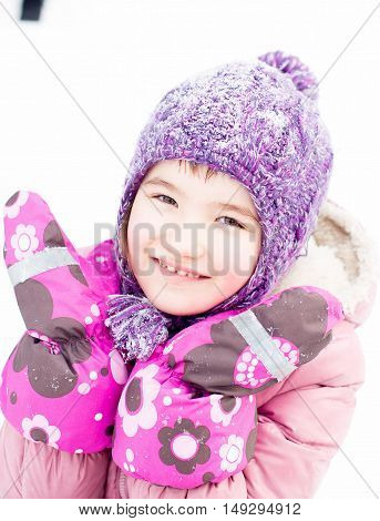 Closeup Portrait Of Gerl In Winter Clothes Outside Playing In The Snow Drifts In The Winter - Russia