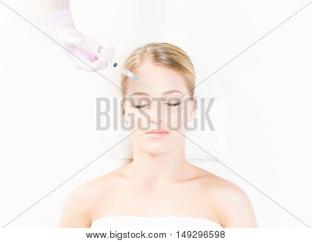Doctor injecting in a beautiful face of a young woman. Plastic surgery concept.