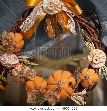 Wreath on the door decorated with handmade textile pumpkins